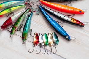 Colorful Fishing Lures on white wood background